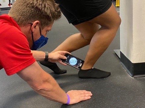 author measuring ankle dorsiflexion with smartphone