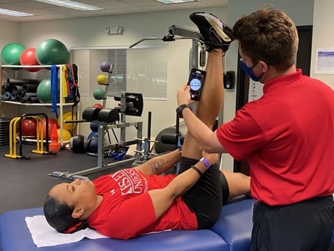 author measuring active knee extension with smartphone