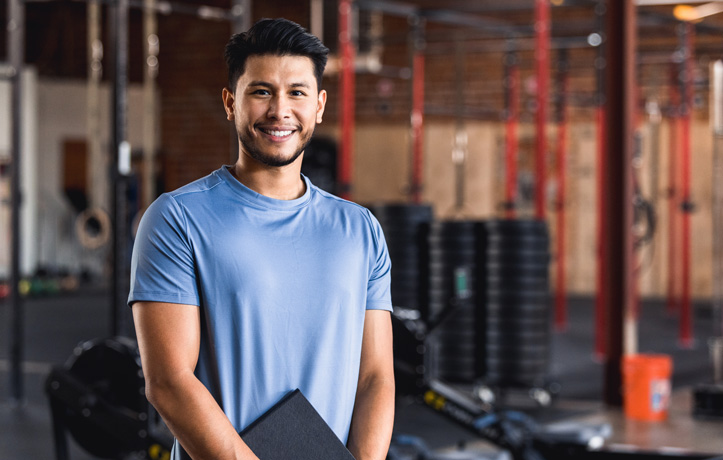 A gentleman standing in a gym with a folder