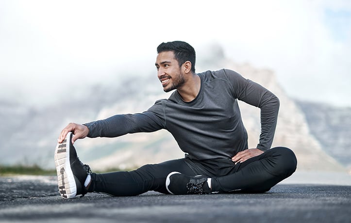 a man stretching near a mountain