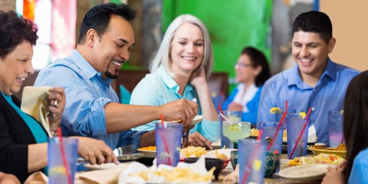 Group of men and women eating at a restaurant together