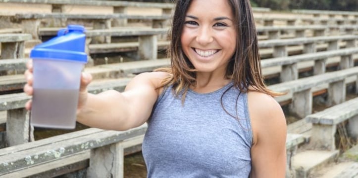 Trainer holding a protein shaker