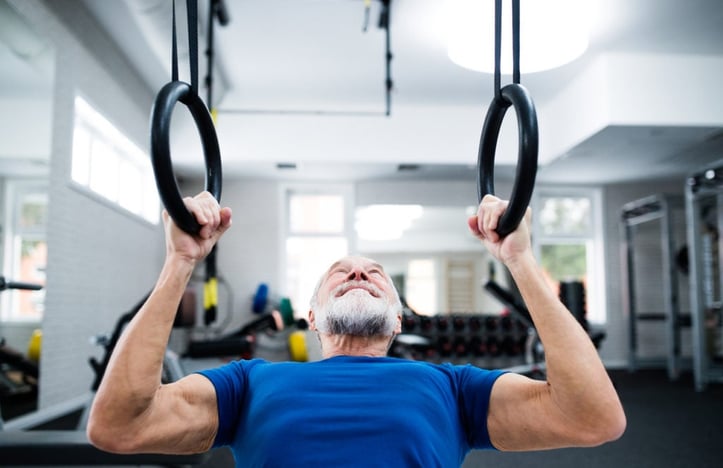 older client doing up-right rows on rings