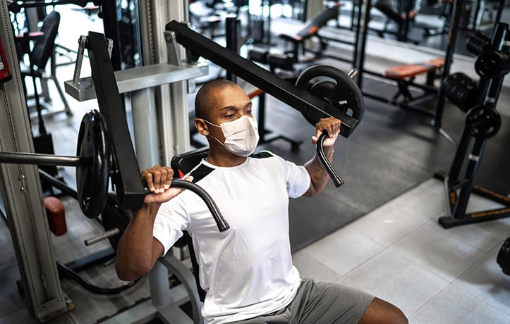man doing strength training with a bench press machine