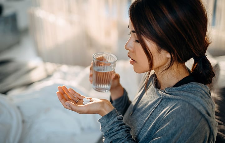 a woman taking supplements to prevent COVID