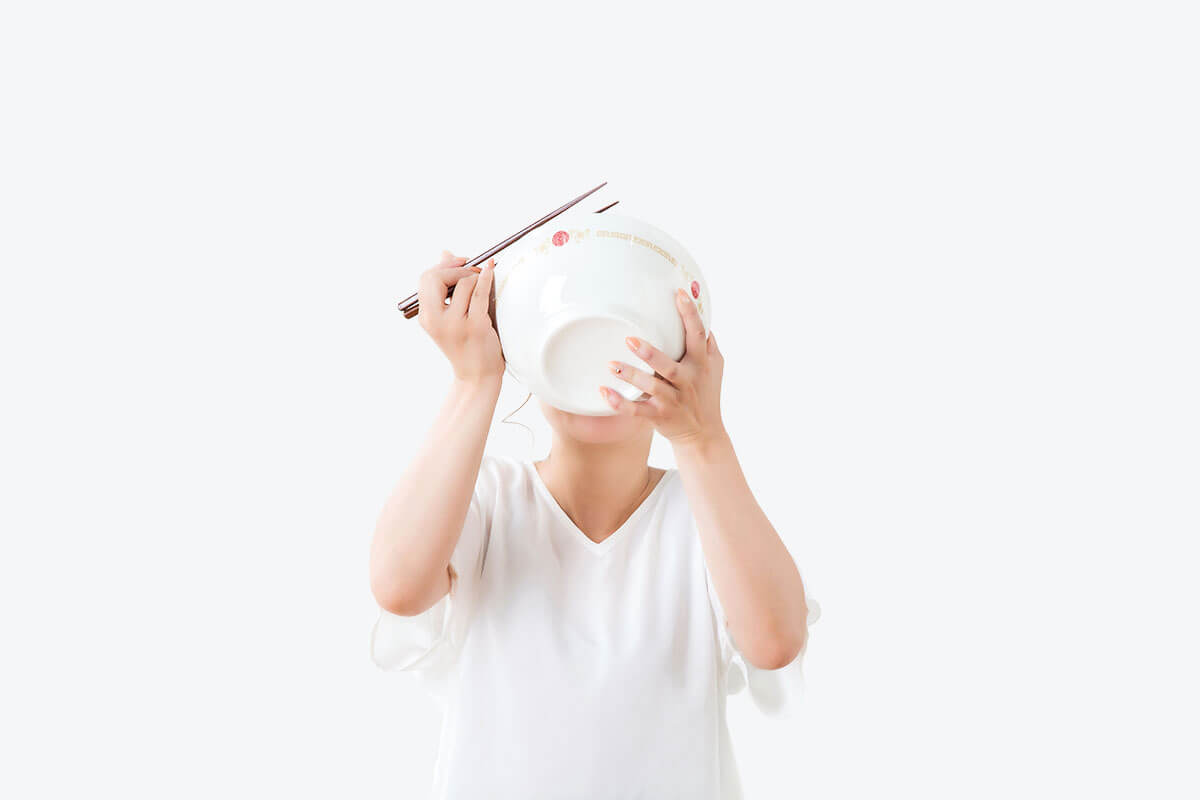 A woman drinking soup out of a bowl