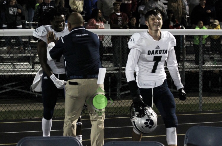 Coach cheering on football players