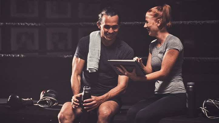 NASM trainer showing client something on tablet