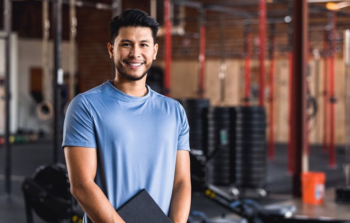 A gentleman standing in a gym with a folder
