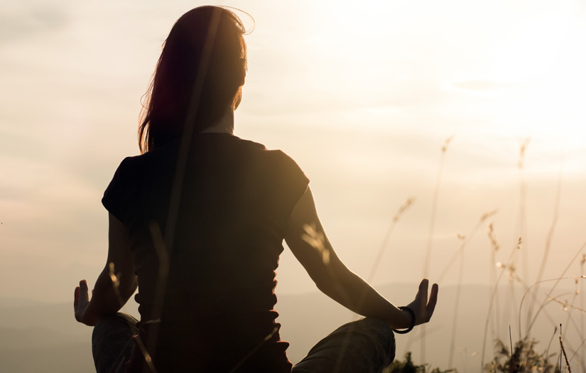 A lady meditating in a field