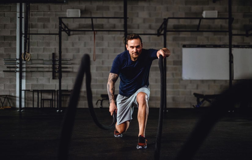a man using the ropes in a gym