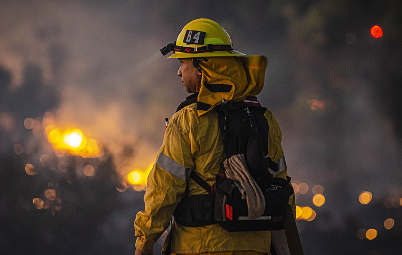 firefighter looking at a fire in the distance
