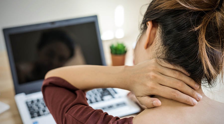 Woman grabbing at her neck seems to be in pain