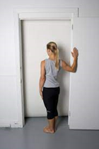 woman doing a standing chest stretch