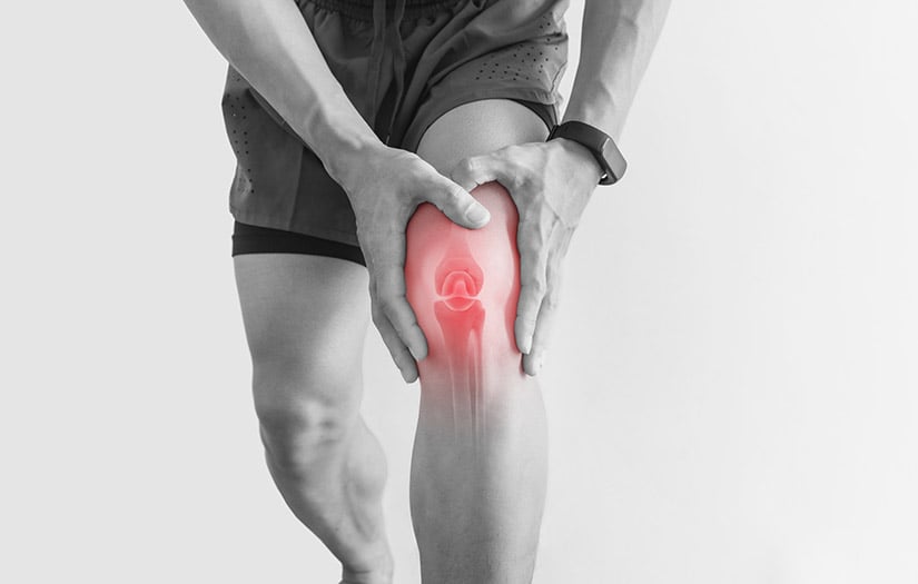 man clutching his knee in pain