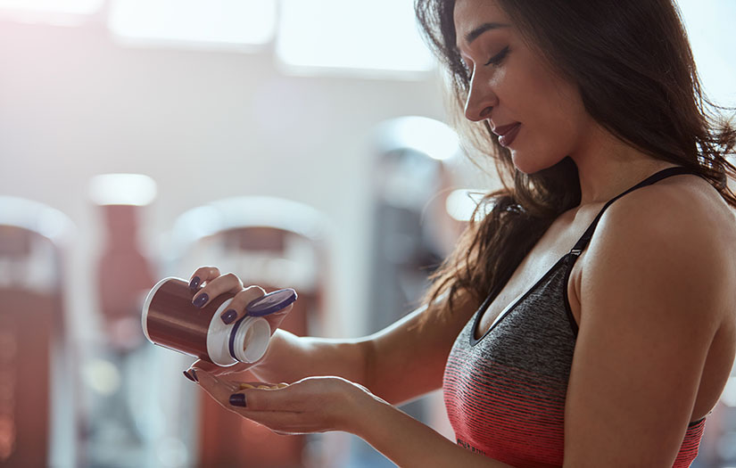 woman taking muscle supplements
