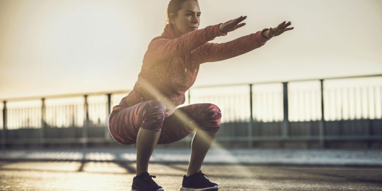 woman doing a squat outside
