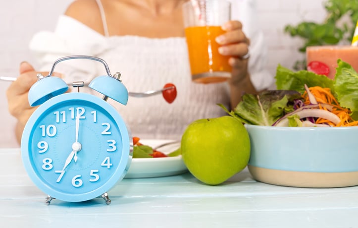 A table with fruits, vegetables and a clock