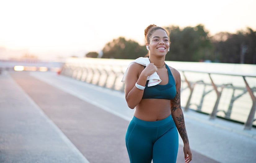 female walking outside with shirt over shoulder